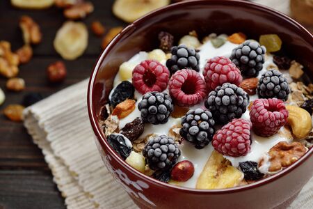Muesli with milk, nuts, fresh berries on wooden brown backgroundの写真素材