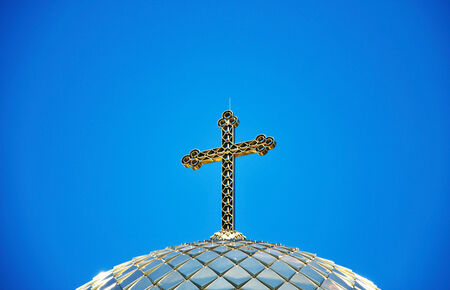 gold cross on a background of blue skyの写真素材