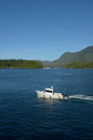 Small motorboat heading out of Tofino Harbour, Tofino, British Columbia, Canada