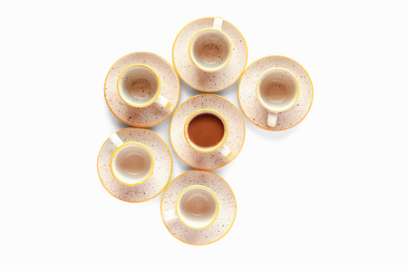 Coffee cups flat lay composition. Warm yellow and brown colors. Isolated on white background morning kitchen scene. Bright soft light. Design resources for social media postsの写真素材