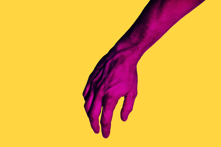 Isolated hand photo on yellow background. Pink hand collage style. Bright pop art template with space for text. Creative minimalistic backdrop.の写真素材