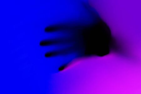Hands in blue and pink neon light gradient behind white surface. Foggy blurred effect for different...