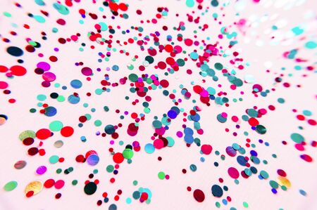 Glitter flying sparkles on pink pastel trendy background. Festive backdrop for graphic design projects. Multicolored random dots.の写真素材