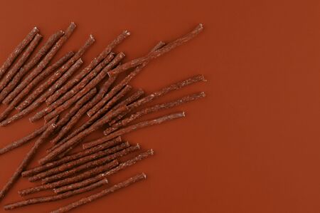 Dog food pattern made with dry snacks sticks. Flat lay texture in brown earthy tones. Home pets, animals feeding. Special diet, training supply. Top view background.の写真素材