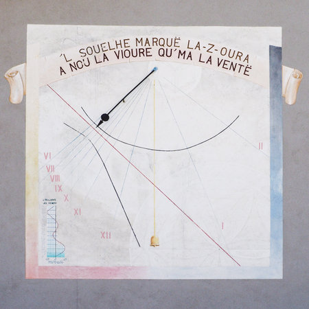 Ancient sundial depicted on building wall in Piedmont, Italy: gray plate with colored lines, occitan...