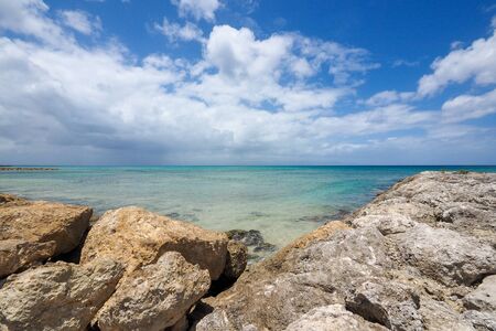 Sunny landscape, horizon over blue sea with lower rocks frameの写真素材