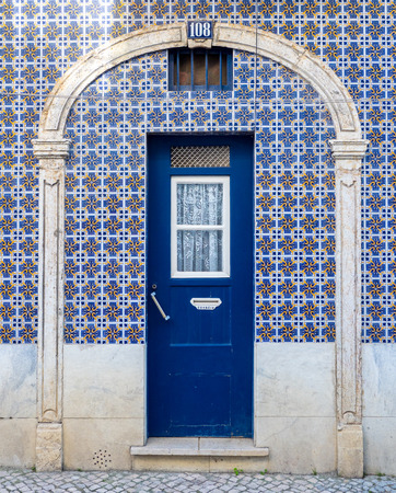 Traditional portuguese lisbon house wooden door with azulejos ceramic tiles surroundingの写真素材