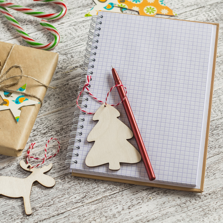 Blank open Notepad, Christmas gifts, candies on a light wooden surfaceの写真素材