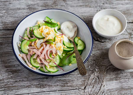 Salad with smoked turkey, cucumber and boiled egg on a light rustic wooden background. Healthy foodの写真素材