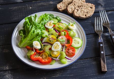 Fresh salad with cherry tomatoes, cucumbers, sweet peppers, celery and quail eggs. Healthy tasty foodの写真素材