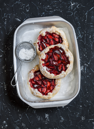 Rustic strawberry pie on a dark stone background. Delicious summer dessertの写真素材