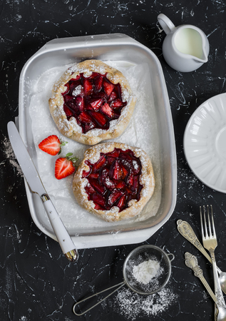 Rustic strawberry pie on a dark stone background. Delicious summer dessertの写真素材