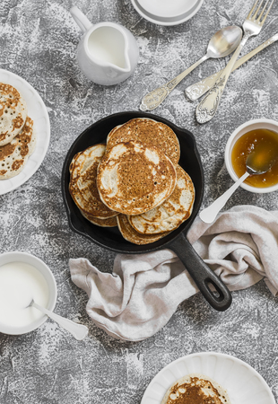 Whole grain pancakes in a cast iron pan on a stone background. Breakfast tableの写真素材