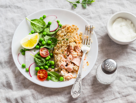 Baked salmon and fresh vegetable salad on a light background. Healthy delicious foodの写真素材