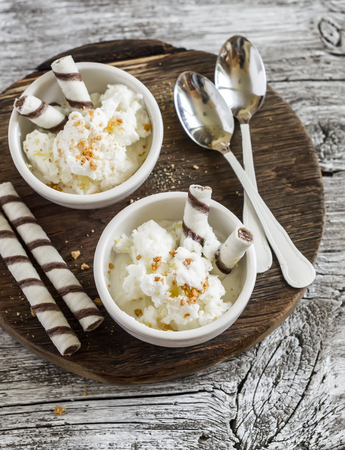 Frozen natural yogurt with cookies on rustic light wood background. Delicious summer dessertの写真素材
