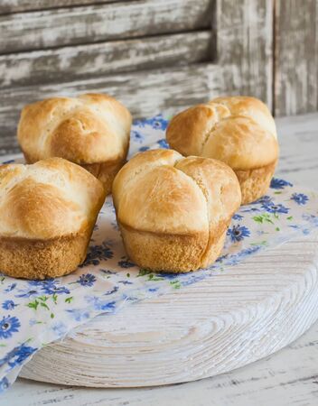 Homemade sweet brioches on a light rustic wood backgroundの写真素材