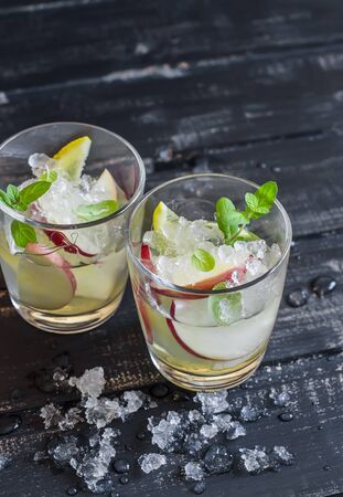 Apple, lemon and mint homemade lemonade on a dark wooden backgroundの写真素材