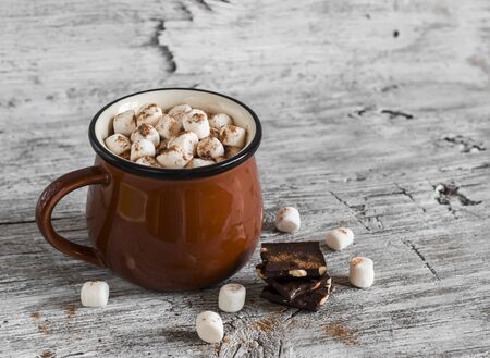 hot chocolate with marshmallows in a ceramic cup on bright wooden surfaceの写真素材