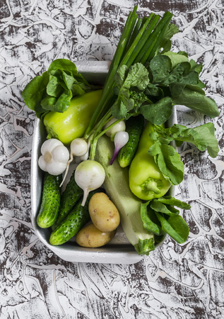 Fresh green and white vegetables - cucumbers, peppers, radish, radish, garlic, onion, potato on a light background. Healthy vegetarian foodの写真素材