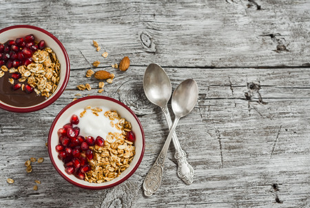 Healthy Breakfast - yogurt with homemade granola and pomegranate on the bright  wooden board.の写真素材