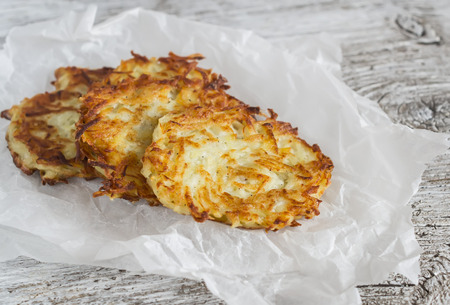 Potato pancakes or latkes on a light rustic wood surfaceの写真素材