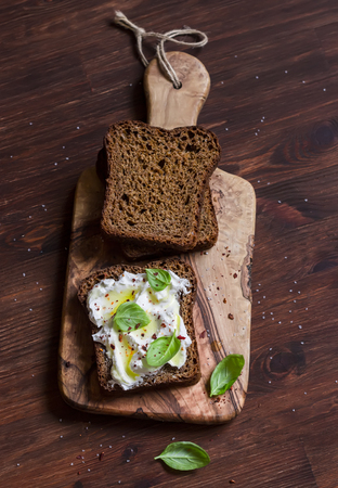 Homemade rye bread and lemon, basil, ricotta and honey bruschetta on a brown wooden table. Rustic styleの写真素材
