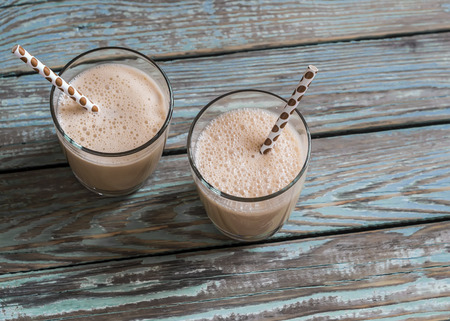 Dulce di leche and ice cream milkshake in glasses on a wooden rustic backgroundの写真素材