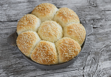 Homemade bread rolls in a vintage pan on wooden backgroundの写真素材