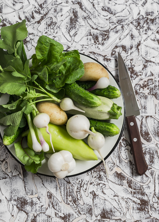Fresh green and white vegetables - cucumbers, peppers, radish, radish, garlic, onion, zucchini  on a light background. Healthy vegetarian foodの写真素材