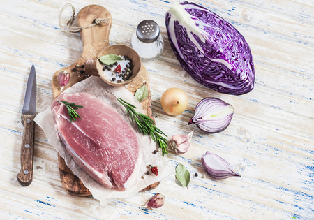 Raw ingredients - meat, red cabbage, onion, garlic, spices and herbs. Cooking delicious and healthy lunch. On light  wooden rustic backgroundの写真素材