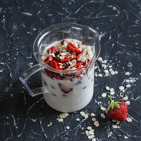 Cooking a berry smoothie with strawberries, oatmeal and flax seed. Healthy energy drink. On dark stone backgroundの写真素材