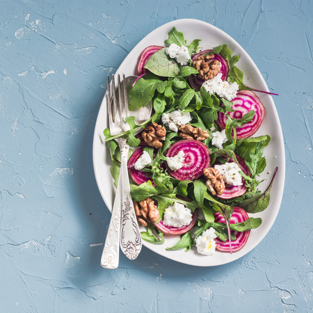 Salad with beets, arugula, feta cheese and walnuts. On a blue background, top viewの写真素材