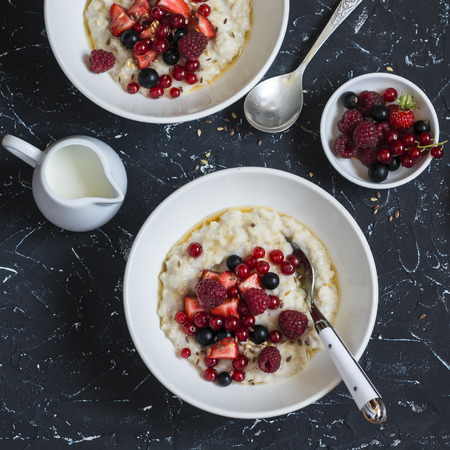 Oatmeal with berries and honey on a dark background. Healthy breakfastの写真素材