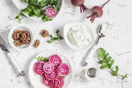 Ingredients for salad or snack - beets, arugula, goat cheese, walnuts on a white background. Top viewの写真素材