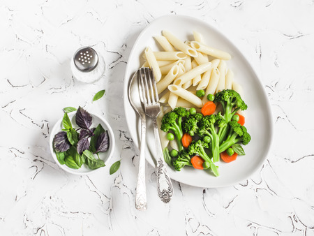 Pasta with broccoli. Delicious healthy vegetarian lunch. On a light backgroundの写真素材
