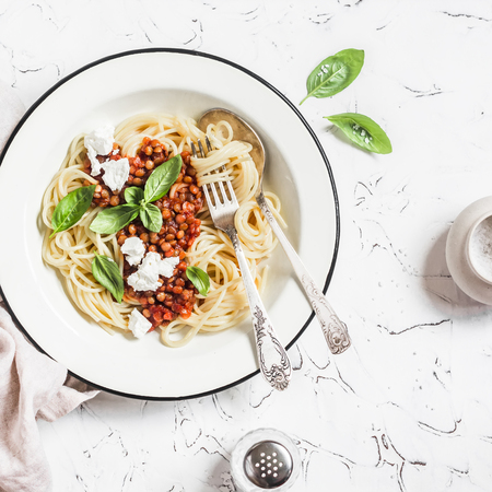 Spaghetti with vegetarian lentil bolognese on a light background. Delicious healthy vegetarian foodの写真素材
