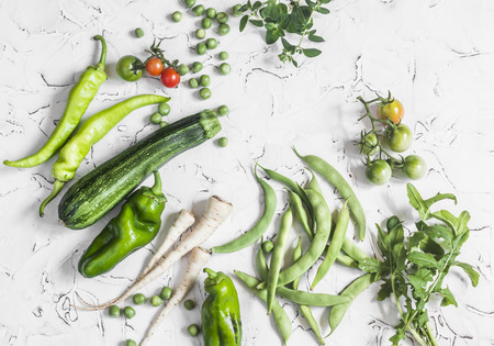 Fresh raw green vegetables - zucchini, green peas and beans, parsnips, peppers, tomatoes, onions on a white background. Healthy  Vegetarian, vegan tableの写真素材