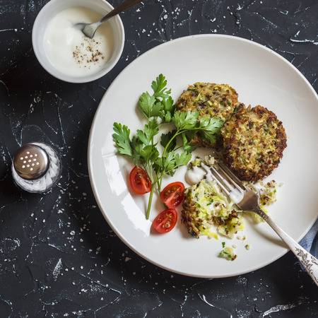 Zucchini quinoa fritters. Healthy vegetarian food. On a dark background, top viewの写真素材