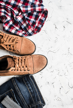 Jeans, checkered shirt and suede boots a light background. Women's clothing. Retro style, top viewの写真素材