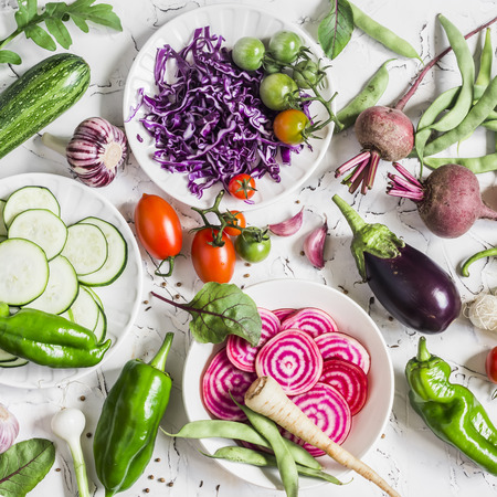 Assortment of fresh vegetables on a light background - zucchini, eggplant, peppers, beets, tomatoes, green beans, red cabbage. Free space for text, top view. Cooking backgroundの写真素材
