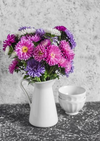 Autumn flowers asters in a white pitcher on a light background. Still life in vintage styleの写真素材