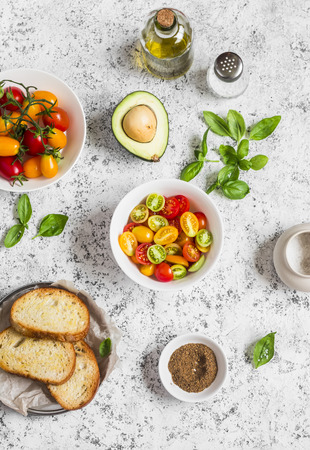Ingredients for bruschetta - tomatoes, avocado, basil, olive oil, bread. On a light background, top viewの写真素材