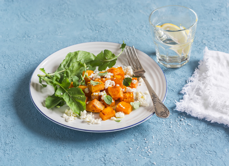 Baked pumpkin and goat cheese salad on a blue background. Healthy foodの写真素材