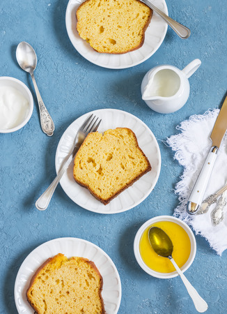Slices of pumpkin cake on white plates on a blue background.  Delicious autumn dessert.の写真素材