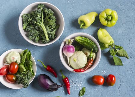 Fresh vegetables - broccoli, peppers, tomatoes, eggplant, squash, turnips on a blue background, top view. Cooking ingredients.の写真素材