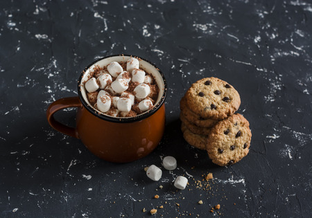 Hot chocolate with marshmallows and chocolate chips oatmeal cookies on a dark background.の写真素材