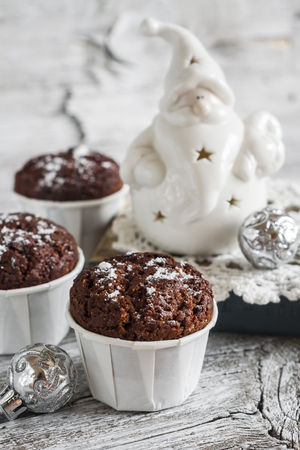 chocolate muffins and ceramic Santa Claus on a light wooden surface, vintage styleの写真素材