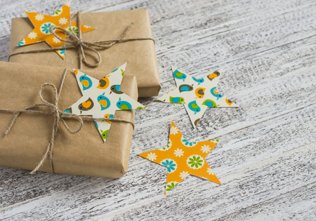 Christmas gifts in kraft paper on the bright wooden surface. vintage and rustic style.の写真素材