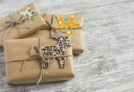 Christmas gifts in kraft paper on the bright wooden surface. vintage and rustic style.の写真素材