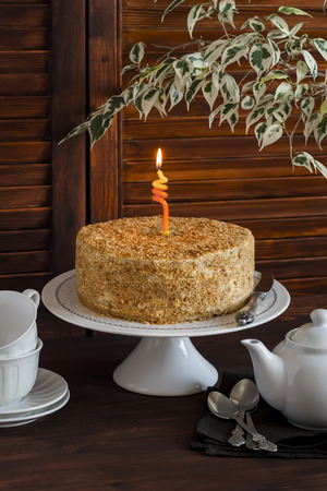 Honey cake , tea cups, teapot and flower on brown wooden table. Tea time. Vintage and rustic styleの写真素材